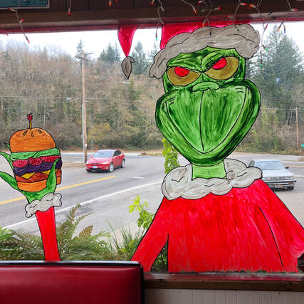 window painting of the Grinch holding a hamburger at skyline restaurant