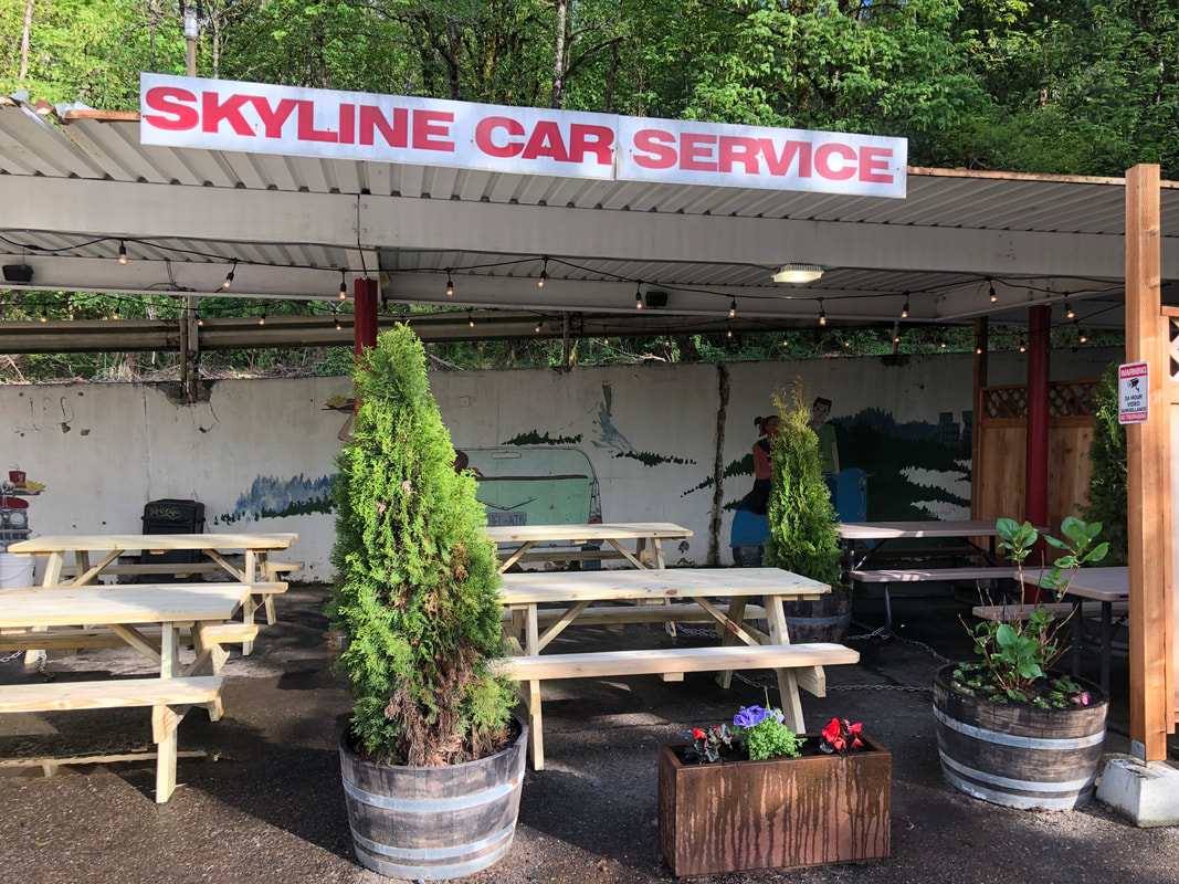 outdoor dining area picnic tables plants sign showing skyline car service